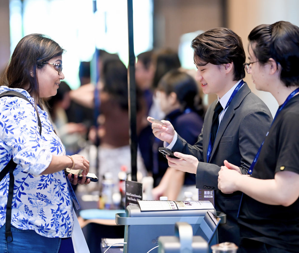 Brand representatives demonstrating a product to a visitor at GCS